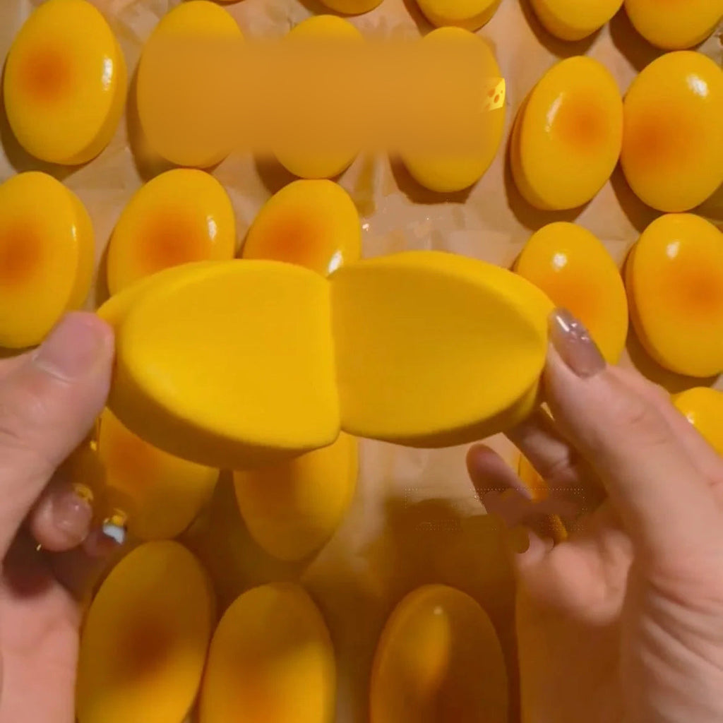 Squishy cheesecake – narančasti kolačić prepolovljen u rukama